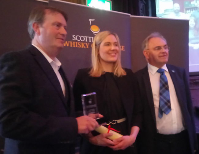 Gavin Brownlie (right) from this year's Readers' Panel presented the Summer Challenge winner, Borders, prize to Zoe White and Alasdair Day of R&amp;B Distillers