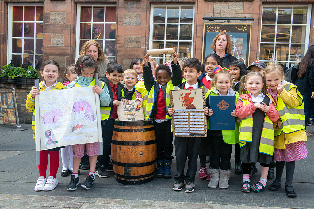 Pupils from Royal Mile Primary School place items in the time capsule
at the Scotch Whisky Experience
