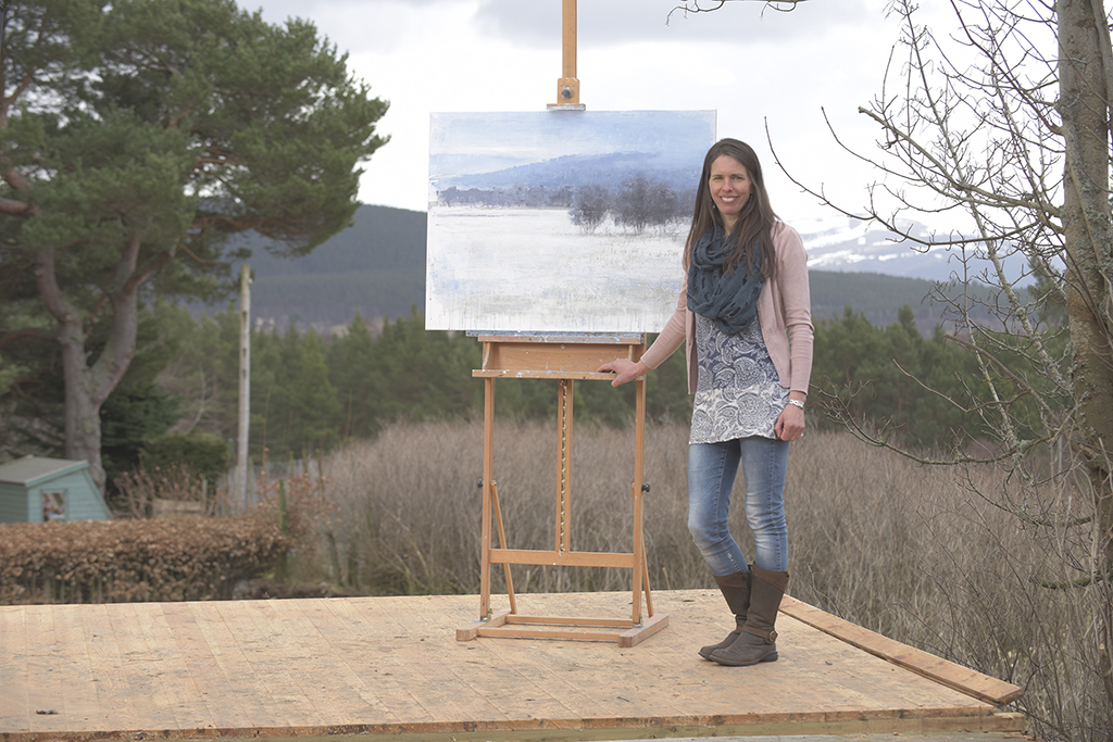 Carina standing in front of the beautiful Cairngorms scenery that inspires her work.