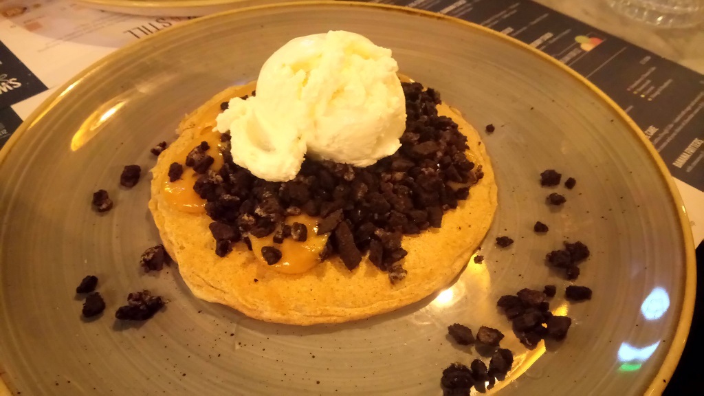 A protein pancake with peanut butter sauce, Oreos and coconut ice cream