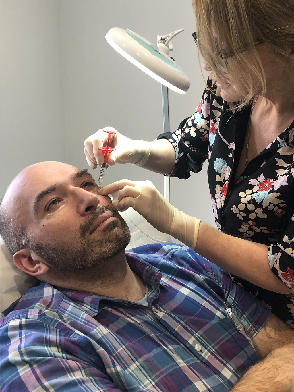 Dr Judy Todd administers an injection to Kenny Smith's face 