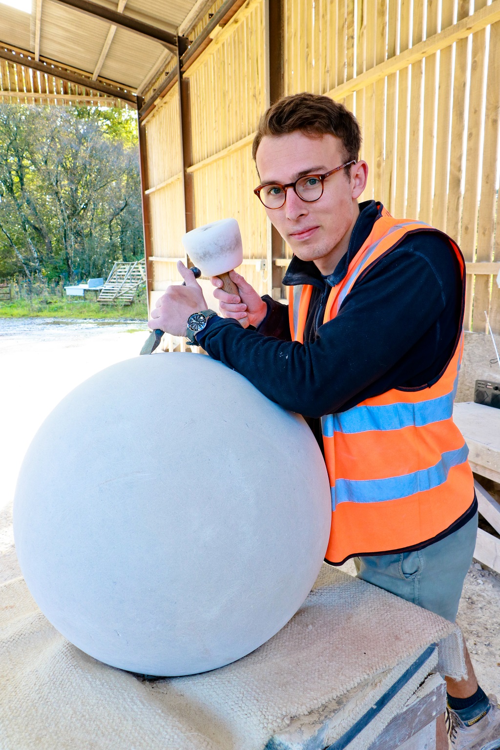 Prince's Foundation student Tom Stainer works on part of an obelisk to be installed at Poundbury