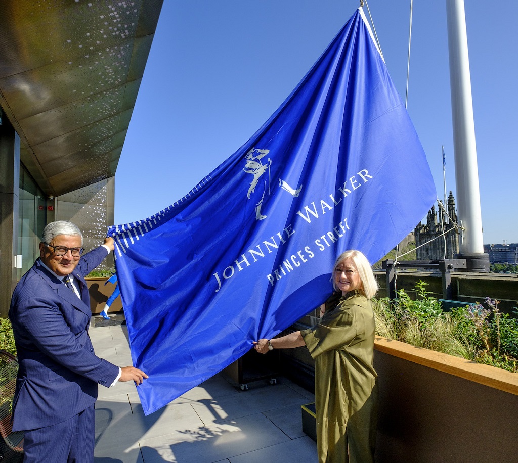 Ivan Menezes, chief executive, Diageo, and Barbara Smith, managing director of Johnnie Walker Princes Street, raise a Johnnie Walker flag