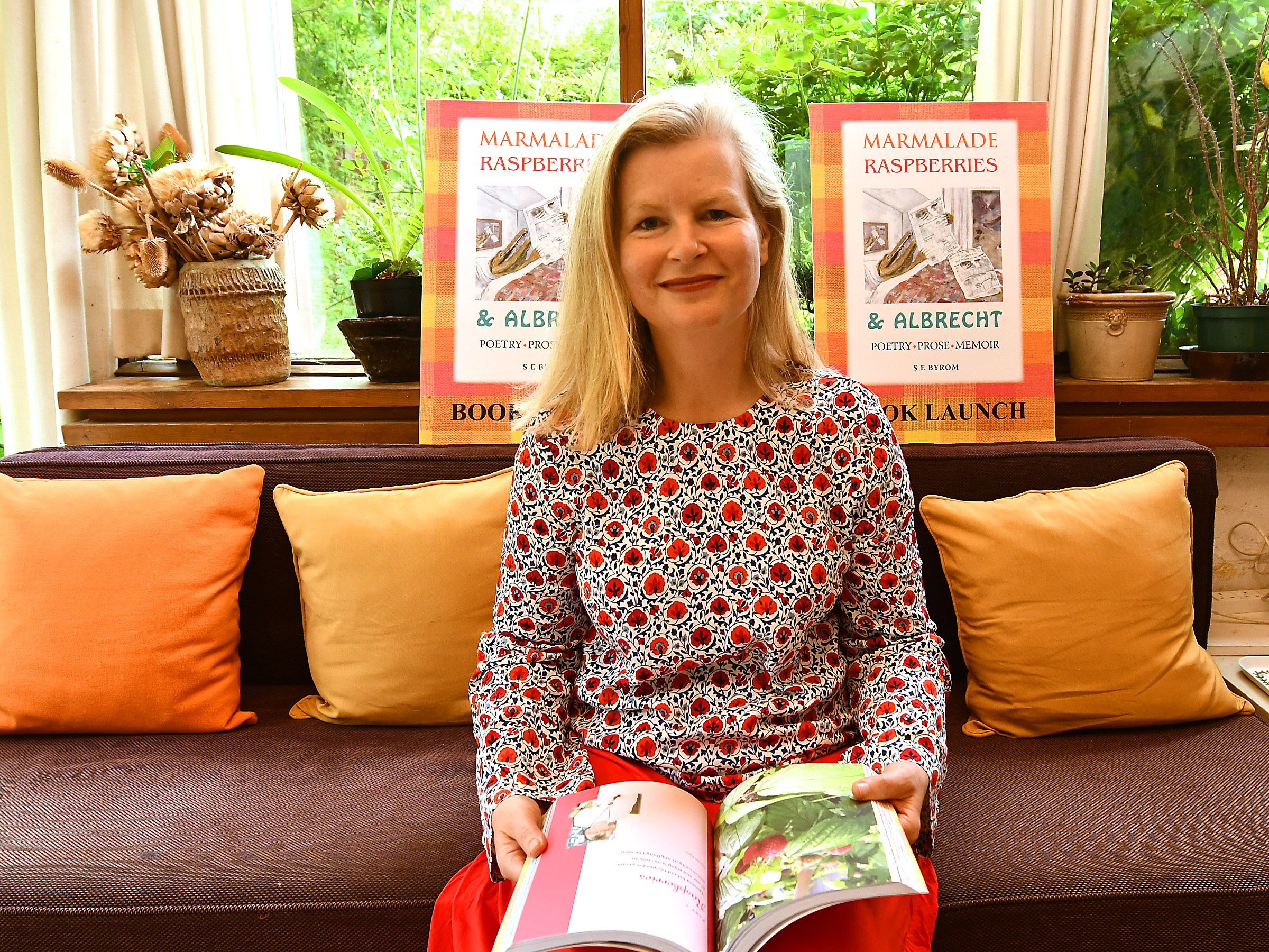 Author-Sarah-Byrom-holding-book-in-home-14q8on99o