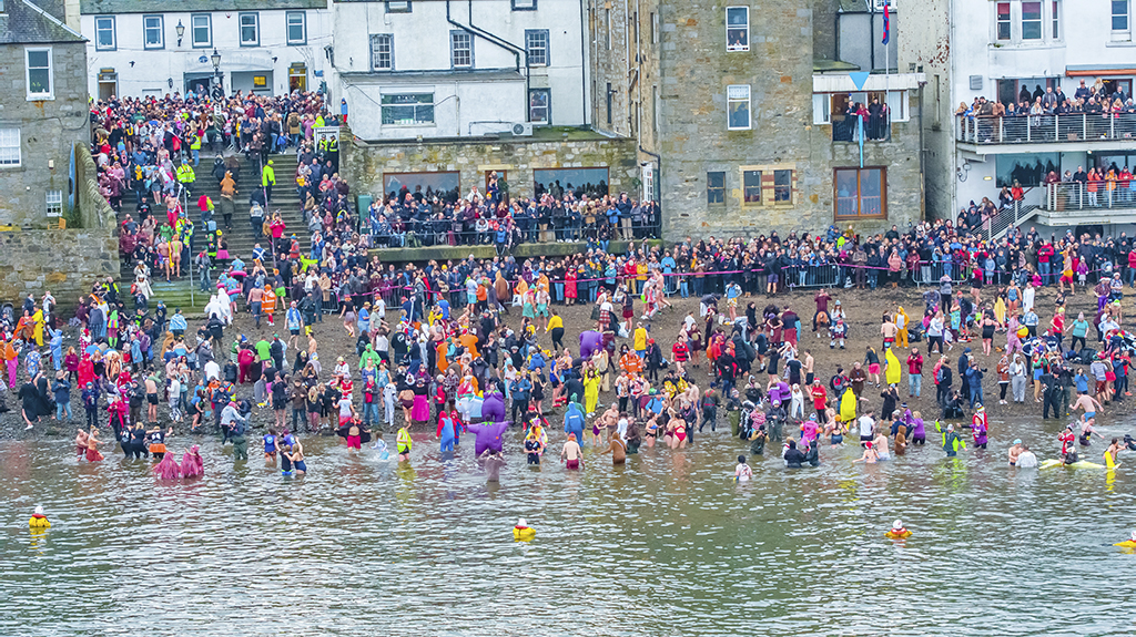 IMAGE DISTRIBUTED FOR EDINBURGH'S HOGMANAY -| The Loony Dook continues its New Year’s Day tradition at Edinburgh’s Hogmanay. In the shadow of the Forth Bridges, and in front of cheering spectators, the dippers in fancy dress raise money for charities.
Dookers march the length of South Queensferry High Street as part of the Dookers’ Parade before launching themselves into the freezing Firth of Forth on Wednesday 1st January 2020, in Southj Queensferry, United Kingdom. (LIAM ANDERSTREM / Edinburgh's Hogmanay via AP Images)