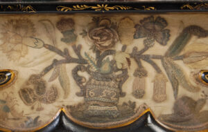 An apron decorated with an urn issuing flowers and foliage dated 1652 is flanked by a lion, birds, insects and acorn tree.