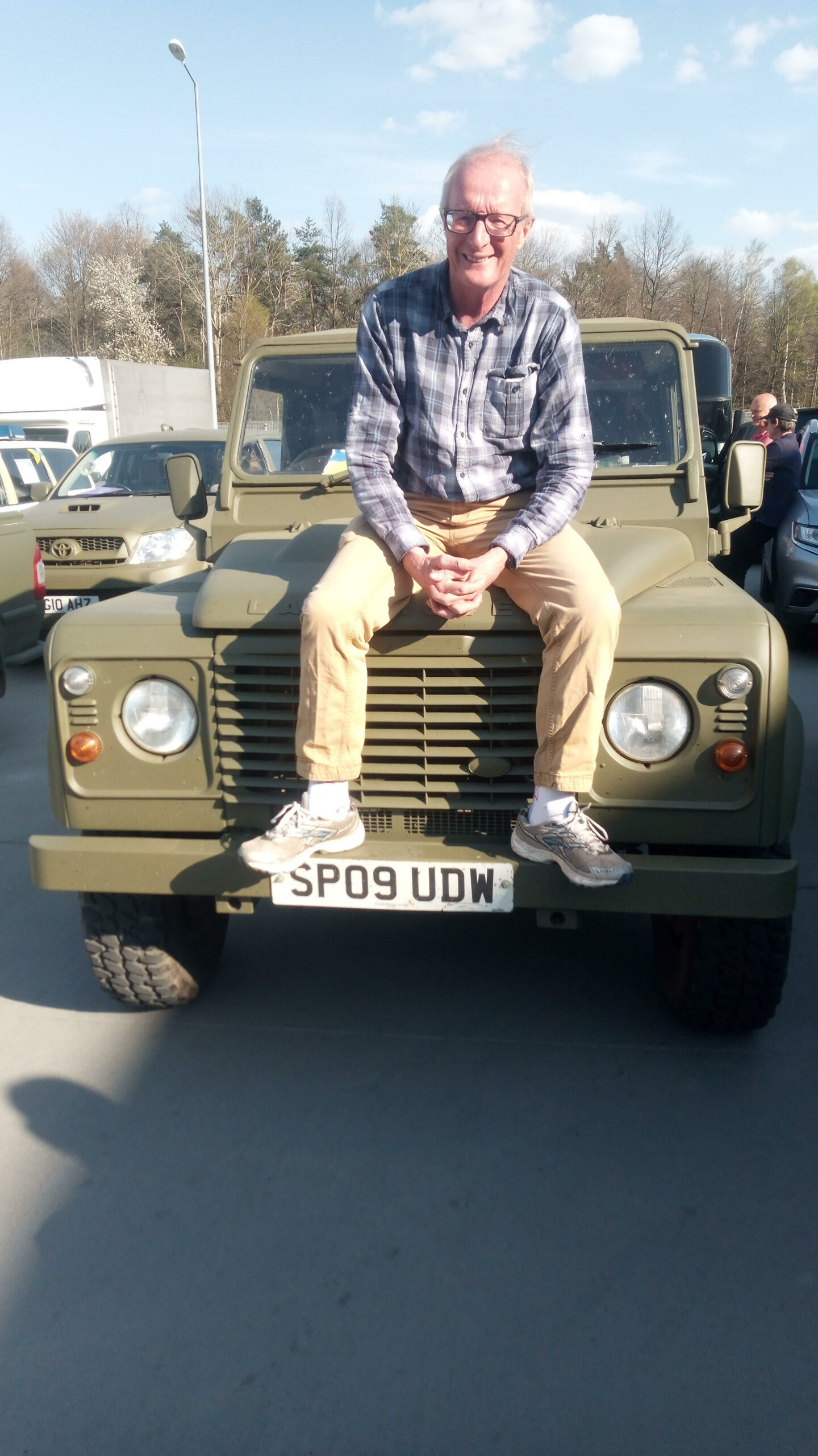  Dr Keith Dawson sitting on the bonnet of a donated Land Rover Defender.