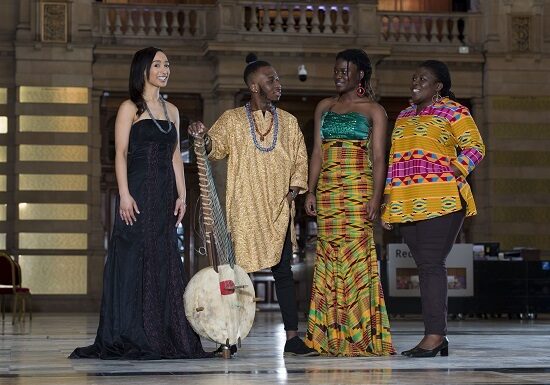 Artist Naa Densua Tordzro (right), Senanu Tordzro (second from right) and niece Linda Tordzro (left) wearing another traditional Africian outfit also on show. They are joined by son Setor playing the kora. 