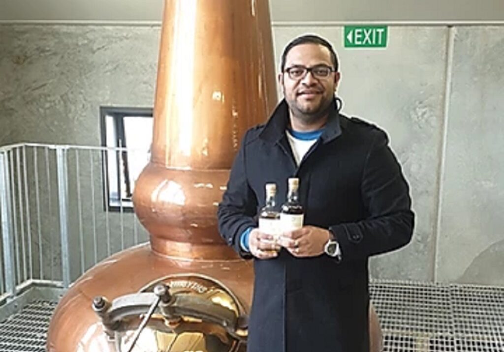 Ash Parmar with bottles from his own collection at Cardona Distillery