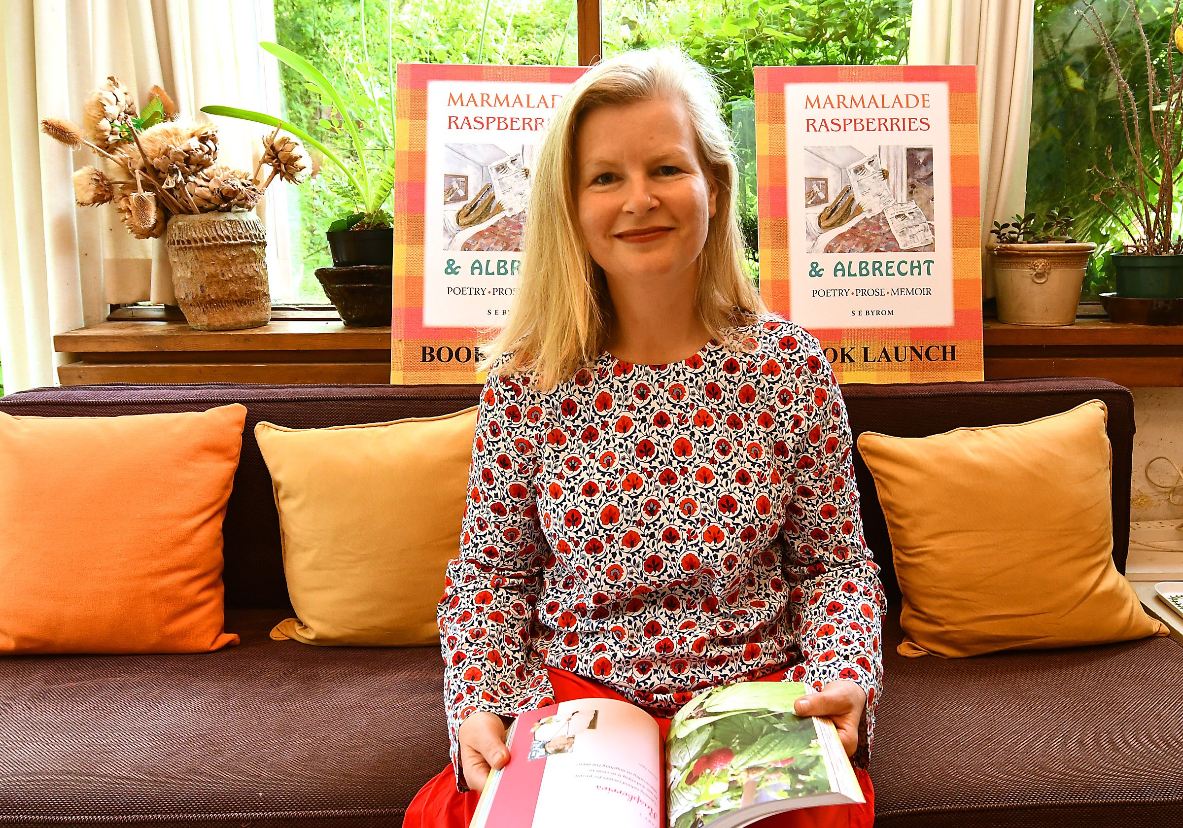 Author-Sarah-Byrom-holding-book-in-home-14q8on99o