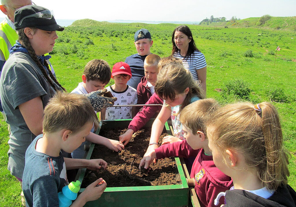 Brora Primary's P5 class looking at the sieving machine