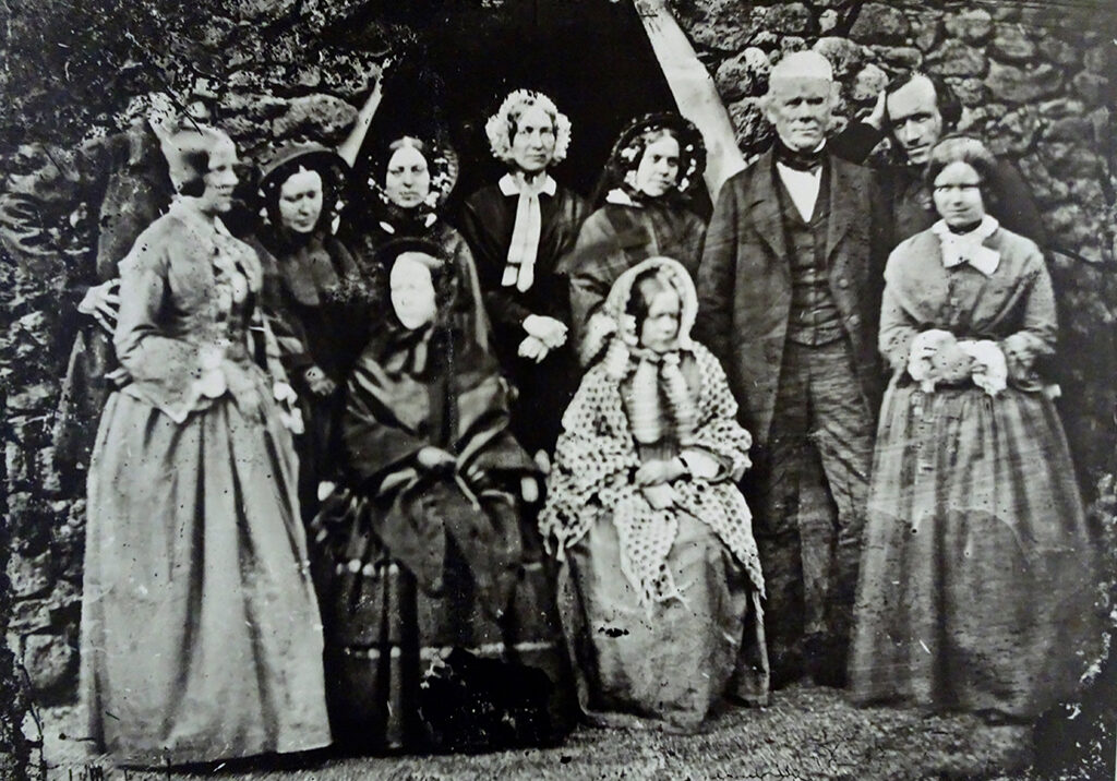 A Cadell family group, with the white-haired man believed to be Hew Cadell and smoothing down his hair is his son Robert Cadell who took the photo - sorting his hair after sprinting to join the group!