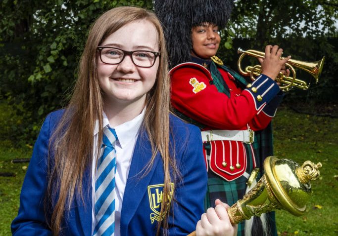 A 12-year-old school student had a huge surprise when she was taken to Redford Barracks and presented with a professional recording made by Army musicians of her rap inspired by the Windrush generation. 
Leila McPhate, from Larbert High School in Stenhousemuir, wrote The World Is A Dark Place as her entry for Never Such Innocence, an international arts competition to give children and young people a voice on conflict.
Leila, who has autism spectrum disorder (ASD), had learned at school how people from the Caribbean were invited to the UK to help it rebuild after WWII but frequently faced injustice and discrimination. After seeing the black British artist Dave on the Brit Awards she decided to address the issue with a rap.
The Army was among the supporters of the 2019/20 competition and Leila’s song caught the eye of Lieutenant Colonel Wendy Faux, the Army’s head of arts, who led the team behind this year’s three-week Army@TheVirtualFringe event.
She was so impressed that she arranged for the Countess of Wessex’s String Orchestra to create a new soundtrack for her rap. Leila was invited to the barracks where Colour Sergeant Richard Kerr, Musician Brittany Johnnie and Corporal Scott MacFarlane of the Band of the Royal Regiment of Scotland presented her with flowers and a copy of the music on behalf of the Army.
Wendy said: “Army@TheVirtualFringe has shone a light on many issues including racism and equality. We have also been trying to support young and emerging talent. So working with Leila has been a perfect way to round off the event.  
“The contribution of people from Commonwealth nations in Africa and the Caribbean to the Army and to civilian life has been immense but is often overlooked, along with the discrimination so many of them experienced.
“The fact that young people like Leila are determined to use their talents to demand a better world gives real hope for the future.
“We are really proud to have been able to bring her together with some s