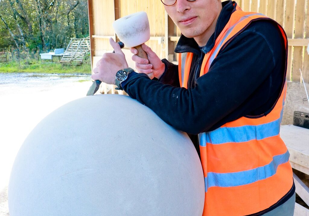 Prince's Foundation student Tom Stainer works on part of an obelisk to be installed at Poundbury