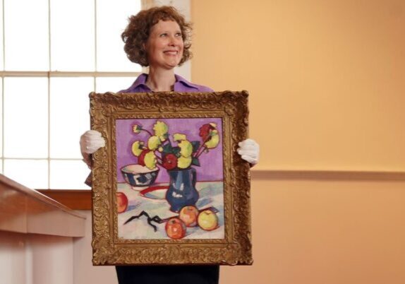 SENIOR SPECIALIST ALICE STRANG WITH SAMUEL JOHN PEPLOE'S STILL LIFE WITH FRUIT AND FLOWERS- IMAGE BY STEWART ATTWOOD (6) Alice Strang with the S.J. Peploe painting. Credit: Lyon & Turnbull/Stewart Attwood