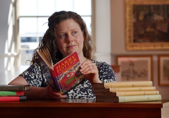 Specialist Cathy Marsden with a First Edition Harry Potter and others - Image by Stewart Attwood Specialist Cathy Marsden with a First Edition Harry Potter. Credit: Stewart Attwood