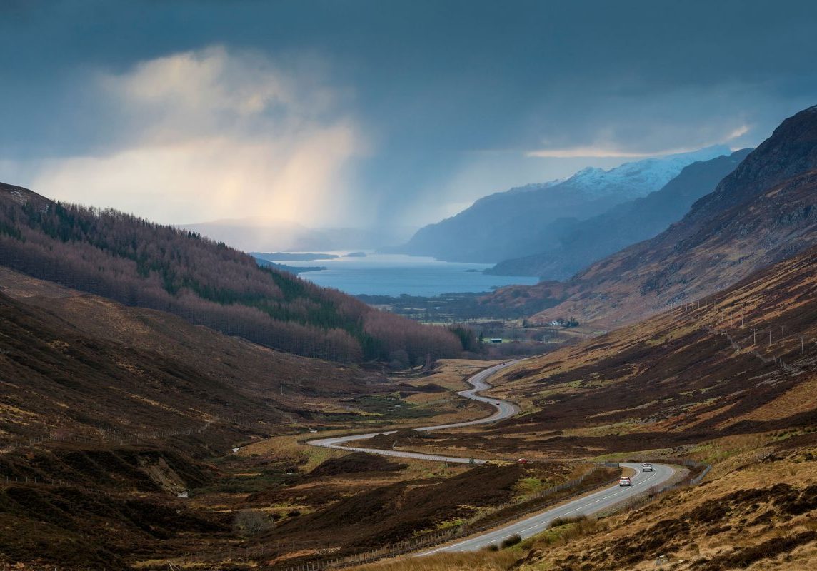 The-road-to-Kinlochewe-with-Loch-Maree-beyond-part-of-the-North-Coast-500-1200x800