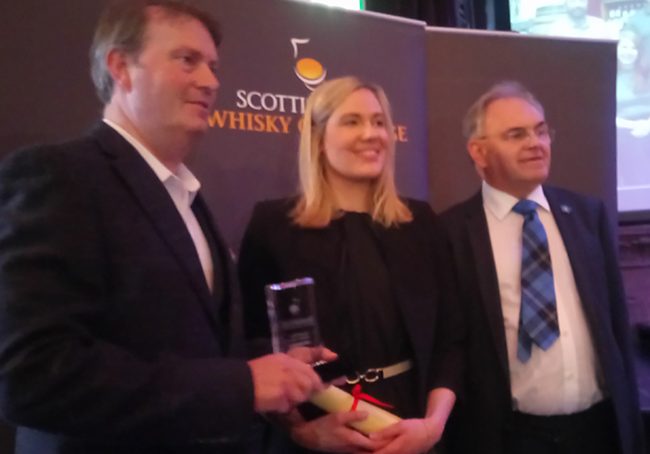 Gavin Brownlie (right) from this year's Readers' Panel presented the Summer Challenge winner, Borders, prize to Zoe White and Alasdair Day of R&amp;B Distillers